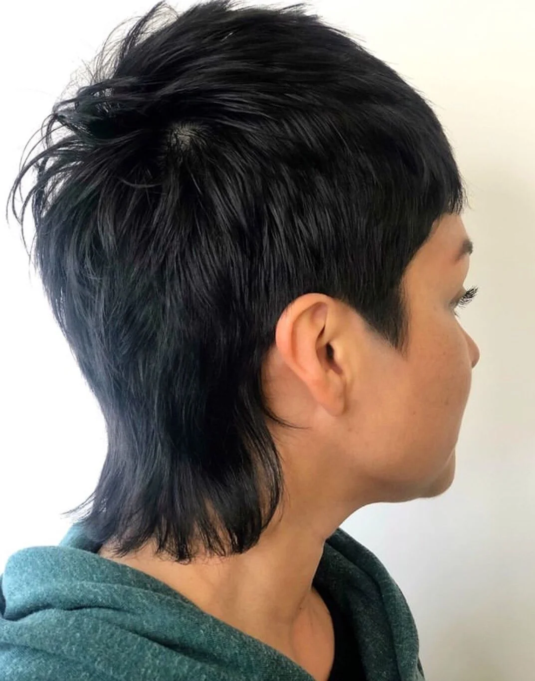 Corte corto oscuro con sienes muy cortas y nuca alargada